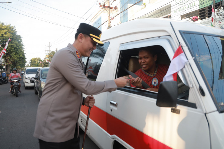 Tebar Semangat Merah Putih Kapolres Jember Turun Jalan Berbagi Bendera dan Cokelat Bagi Pengendara